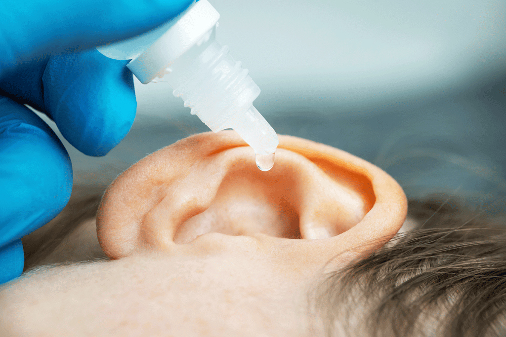Child getting ear cleaned with peroxide